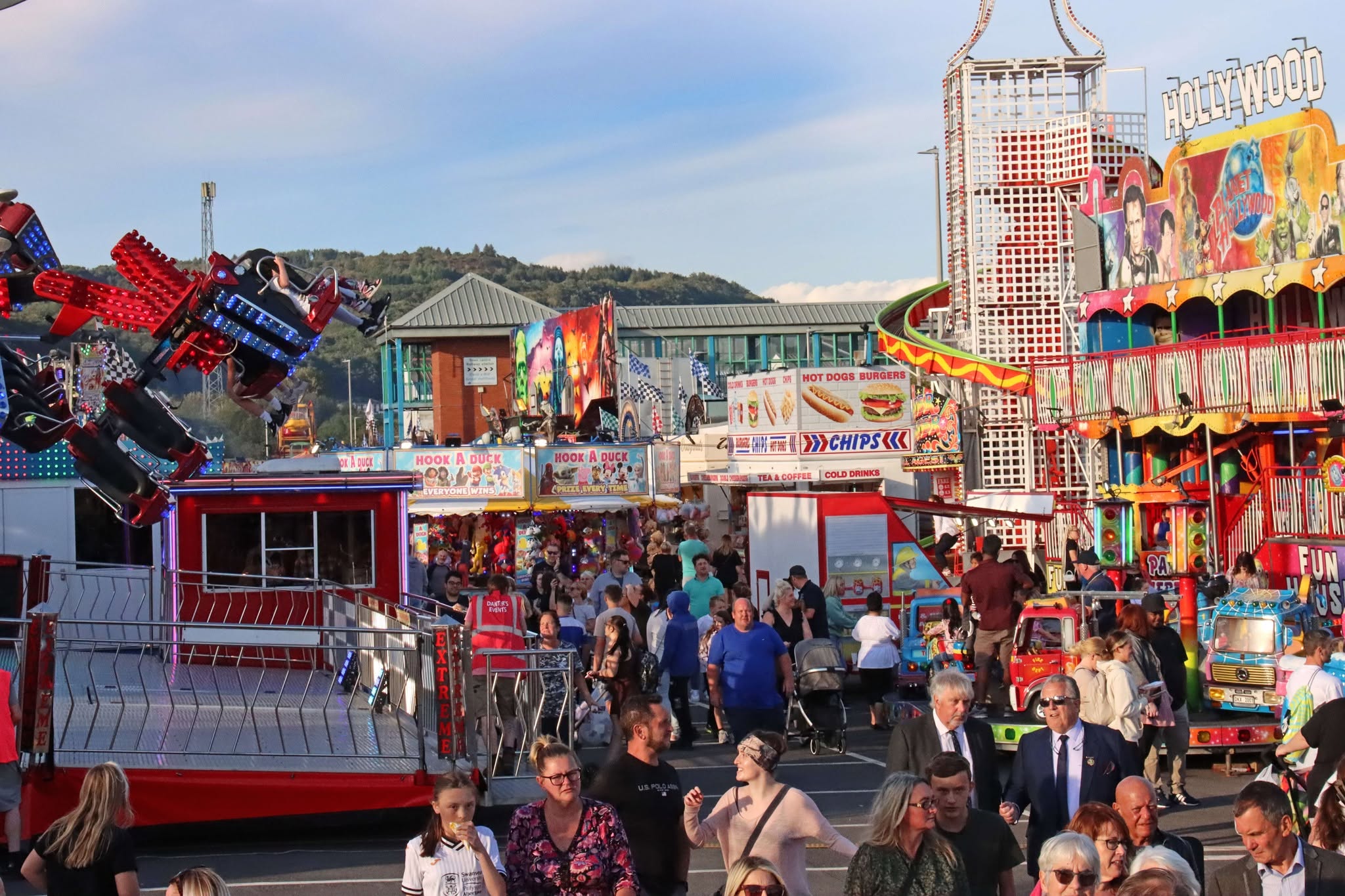 Neath Fair with colourful carnival rides and visitors walking through the fairground.