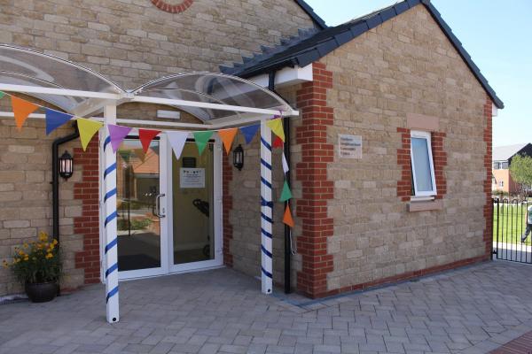 A photo of the Northern Neighbourhood Community Centre's entrance with bunting decorated on the porch area.