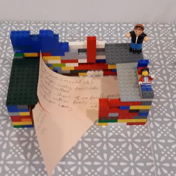 A house built of Lego with a handwritten note 