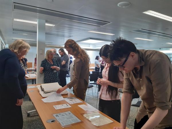 A group of people discussing and looking at materials in the Lothian Health Services Archive