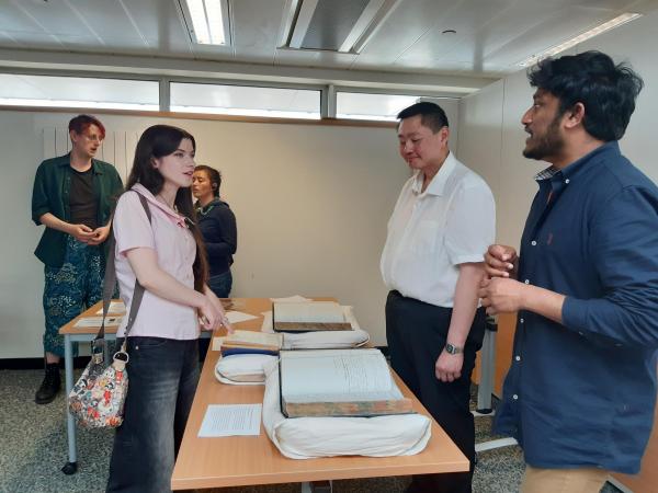 A group of people discussing and looking at materials in the Lothian Health Services Archive