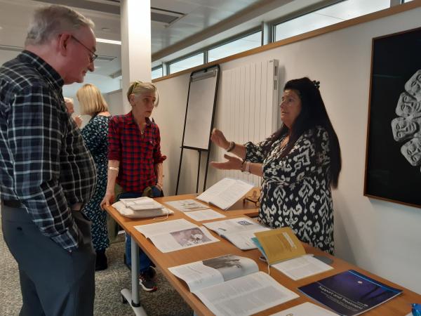A group of people discussing and looking at materials in the Lothian Health Services Archive