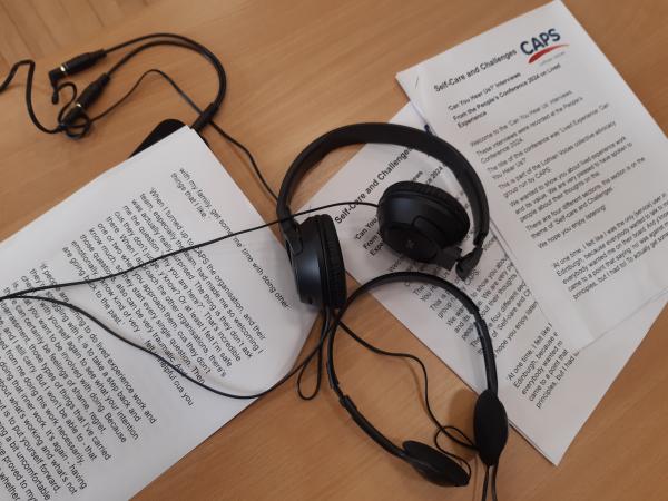 Two pairs of headphones and a number of transcripts on a table