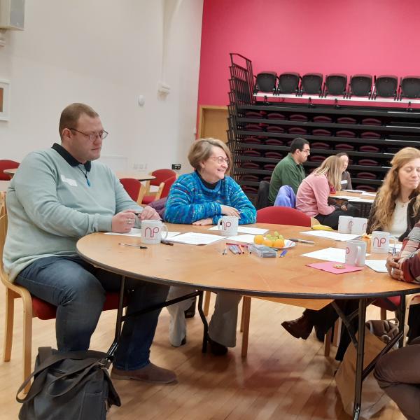 A group of people sitting around a table chatting.