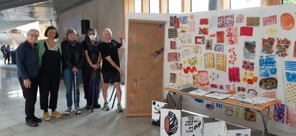 The group at the Scottish Parliament with their art work.