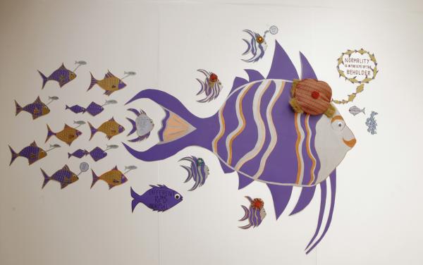 A wall painting of a shoal of fish, an artwork 'Different is the new normal' by Jenny Jones.