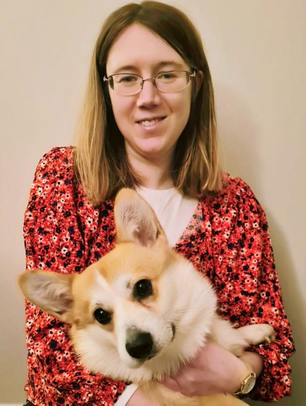 A picture of Niamh smiling, with her dog