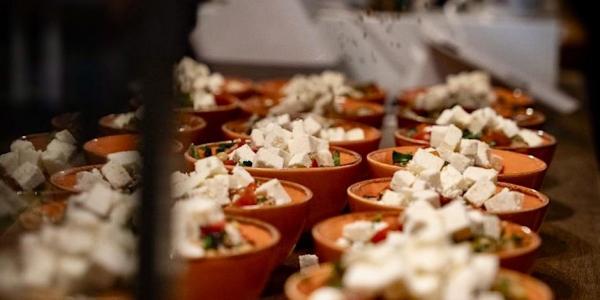 Rows of terracotta bowls containing mezze style food 