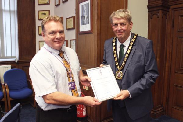 Cllr Tierney receives the Customer Service Excellence certificate from Fenland District Council Chairman Cllr Nick Meekins