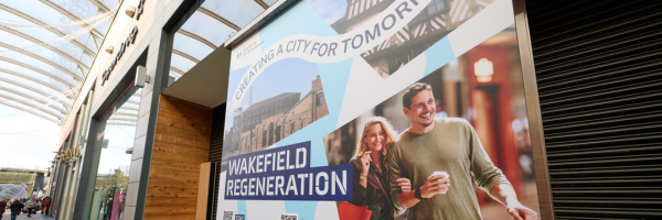 A photo of a shop window with text that says "Creating a city for tomorrow. Wakefield Regeneration"
