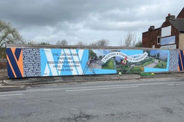 A photo of construction hoardings that say "The Castleford Riverside regeneration project will transform this area"