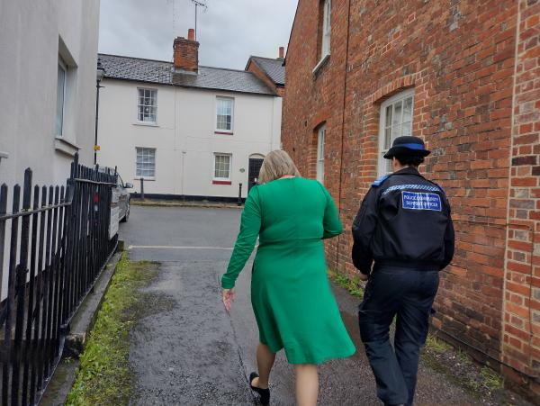 Photo from behind of Police and Crime Commissioner Lisa Townsend walking down an alley in Dorking with local Police Community Support Officer (PCSO) Penny.