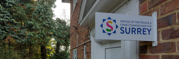 outside of the office of the police and crime commissioner for surrey with logo sign near door