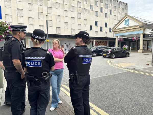 Police and Crime Commissioner Lisa Townsend standing and speaking with three police officers in Camberley town centre