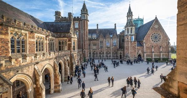 an ornate and old school building with pupils walking in courtyard