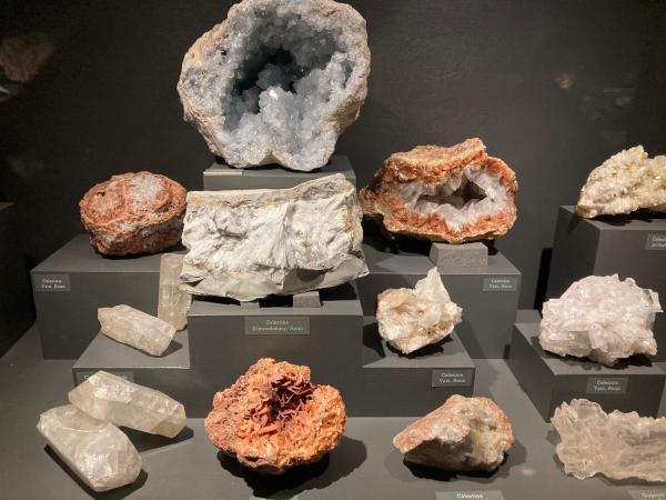 A group of rocks and crystals in a museum display case