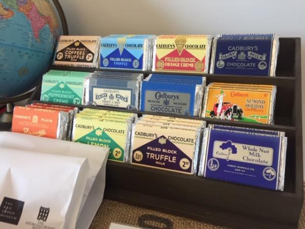 a selection of blocks of chocolate from museum archives laid out on display shelves