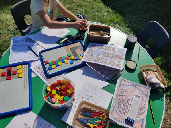 a child is making mosaic patterns on a craft table