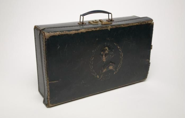 a brown leather suitcase with an embossed figure of lady on