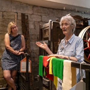 A woman speaking in front of machinery