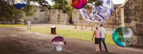 People walking around ruined castle grounds 