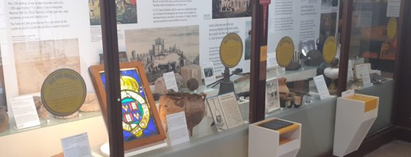 A museum display showing stained glass and other artifacts.