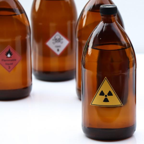 Brown bottles with hazard labels on them. 