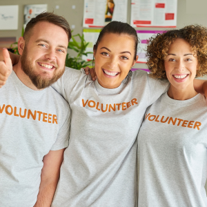 A group of three people wearing grey t shirts which read 'volunteer'