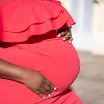 A pregnant woman with her hands cradling her bump