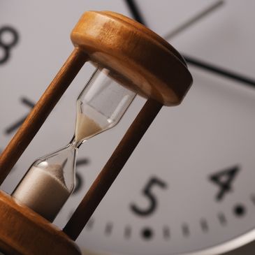 An egg timer in front of a clock