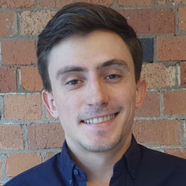A person (Jack Cheshire) is smiling at the camera