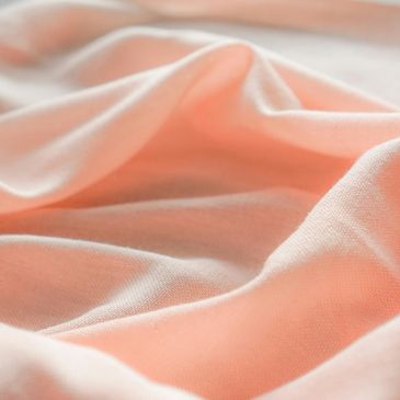 pale pink fabric with folds and curves in it