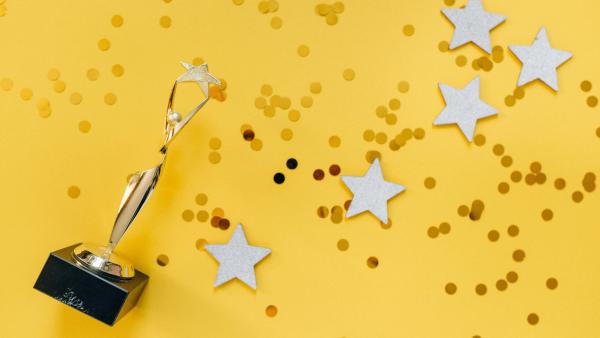 Award on a yellow background with star confetti