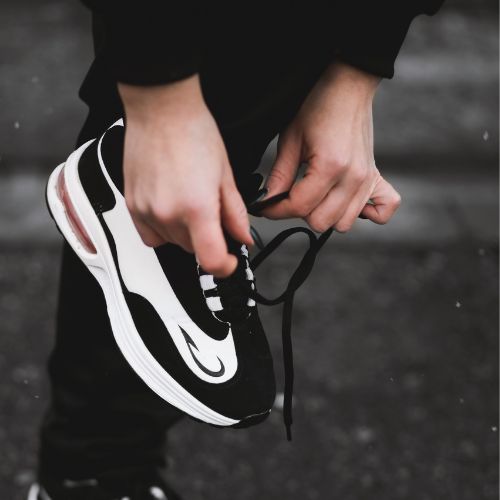 Hands lacing up a running shoe