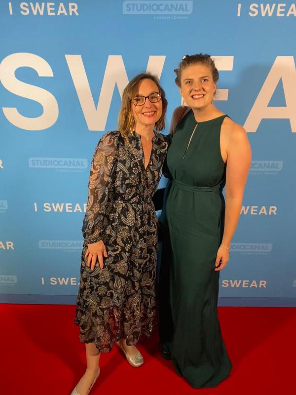 Two people standing on a red carpet