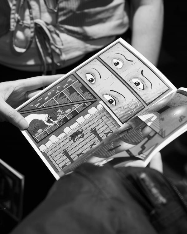 Attendees at the exhibition reading the comic