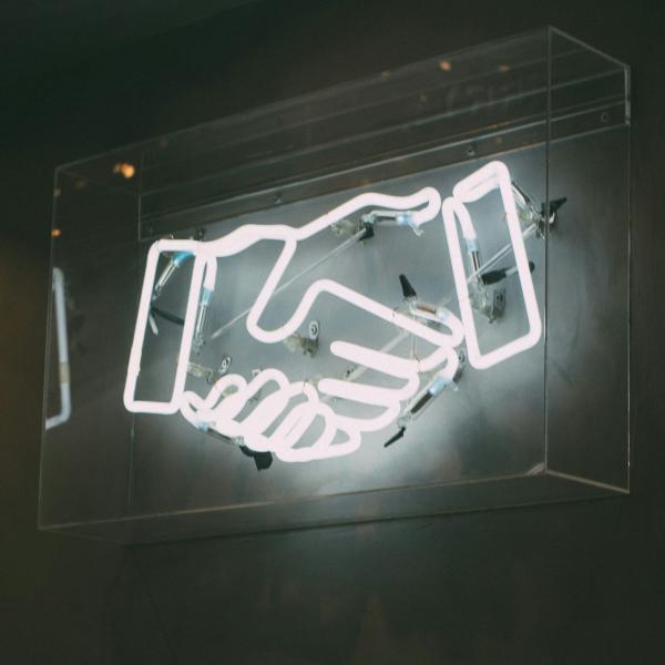 Neon light in the shape of a handshake