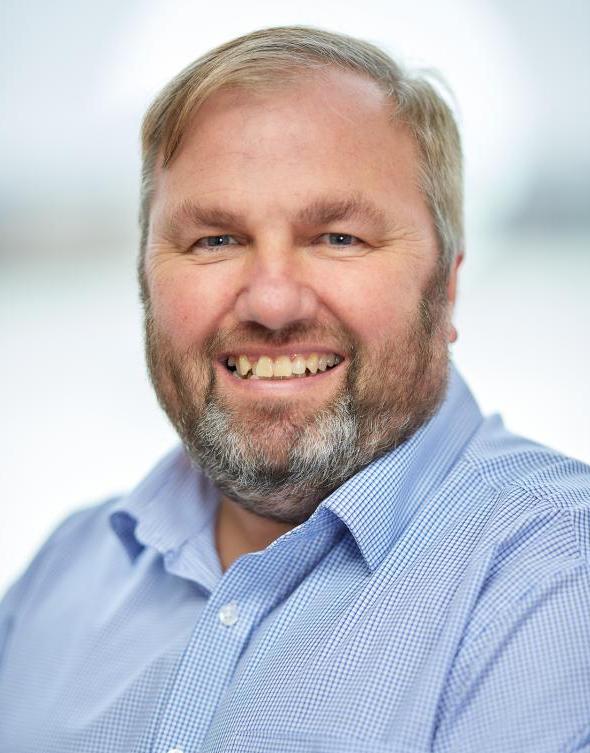 Profile picture of a person in a light blue shirt, smiling at the camera