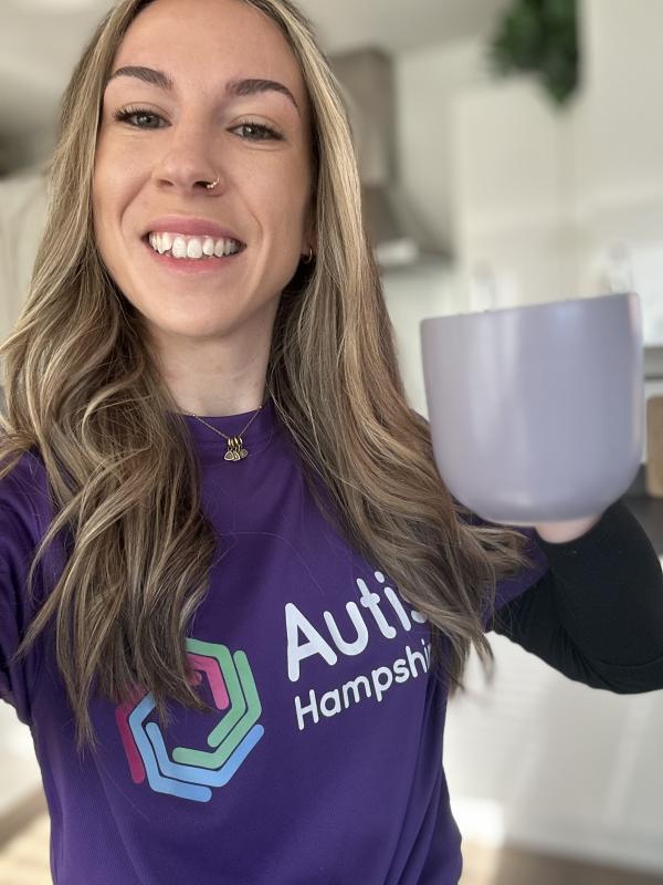 An Autism Hampshire colleague poses in purple with a purple mug of tea.