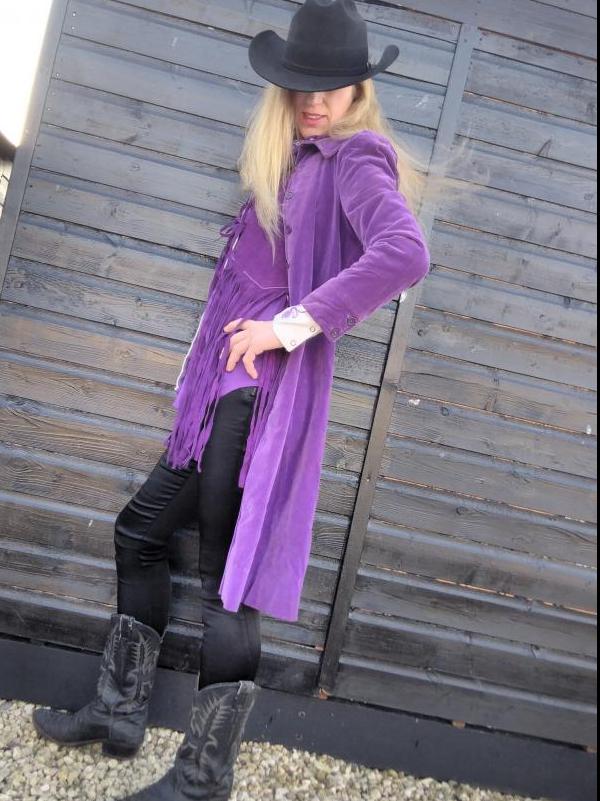 The store manager stands outside in purple cowboy themed gear.