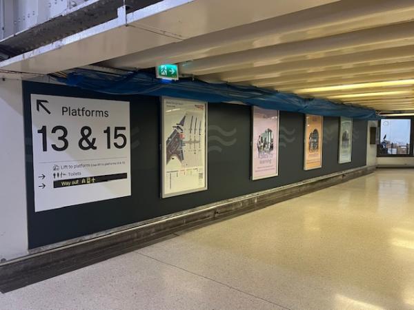 Picture of the hoardings at Bristol Temple Meads Station. There is also a sign which reads 'platforms 13&15'