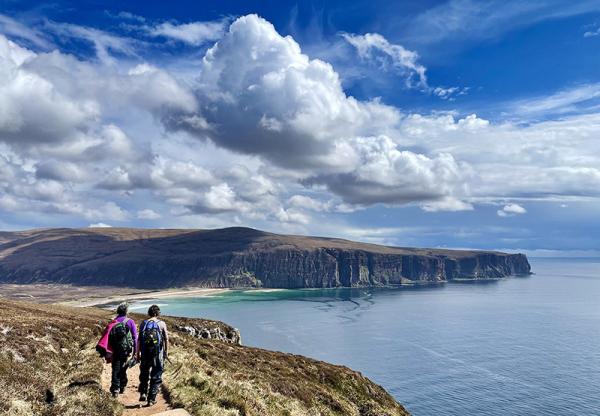 People walking near cliffs in the highlands