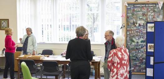 A small group of people gathered in discussion in a library