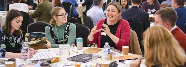 A group of people talking at a conference event