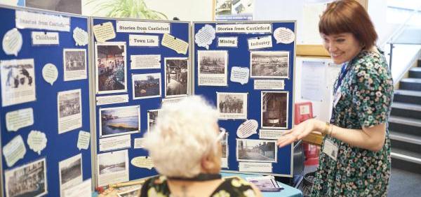 Two people talking next to a heritage display