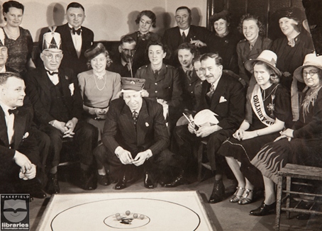An historic image of a group of people watching a marbles tournament