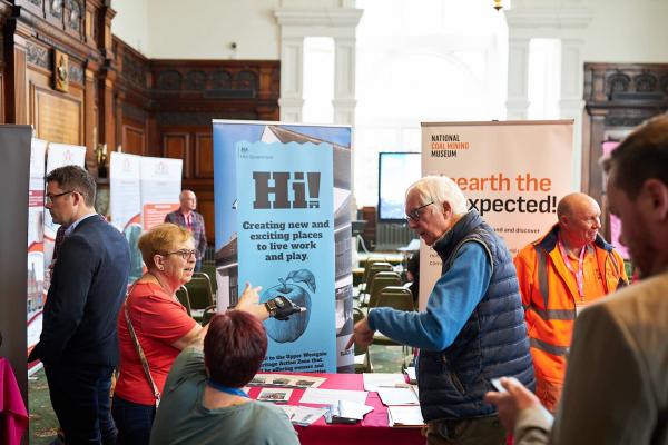 People talking, gathered around a heritage showcase stall