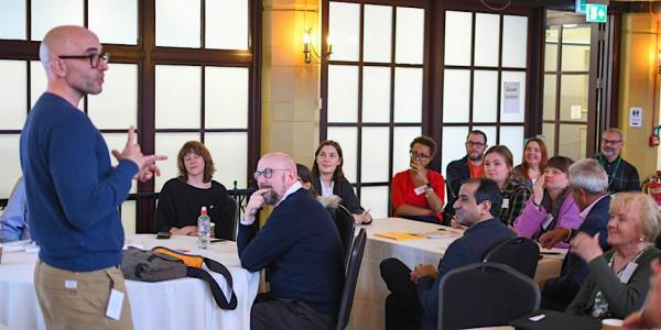 A speaker presenting to an audience at a conference event