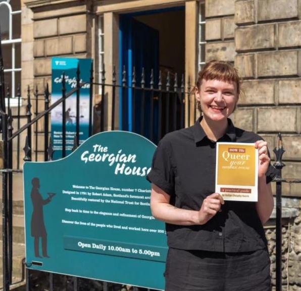 Photo of a person holding a publication and smiling