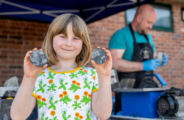 A child holding up two rocks in their hands